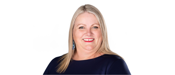 A professional headshot of a friendly woman smiling against a white background.